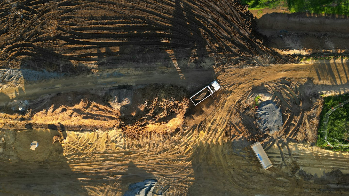 A white dump truck sits on an active construction site.